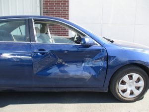 blue car with a big dent in passenger door