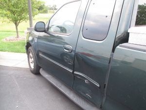 side impact damage to a green Ford truck