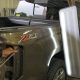Collision Center of Andover technician working on an auto body repair to handle paintless dent repair on a gold truck.