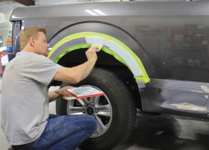 Collision Center tech doing paint job on truck in Andover auto shop