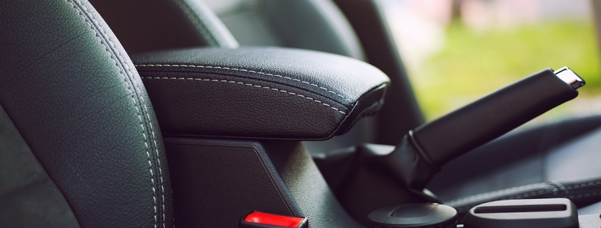 Parking brake engaged inside a vehicle with black leather interior, not doing so is a common bad habit for drivers