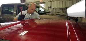 Collision Center of Andover auto body technician doing PDR to fix dings