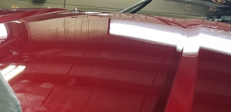 Shiny smooth red car hood fixed using paintless dent repair