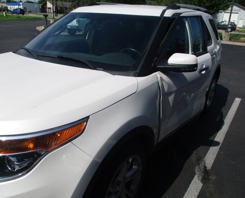 White Ford Explorer SUV in Andover parking lot with car door dings